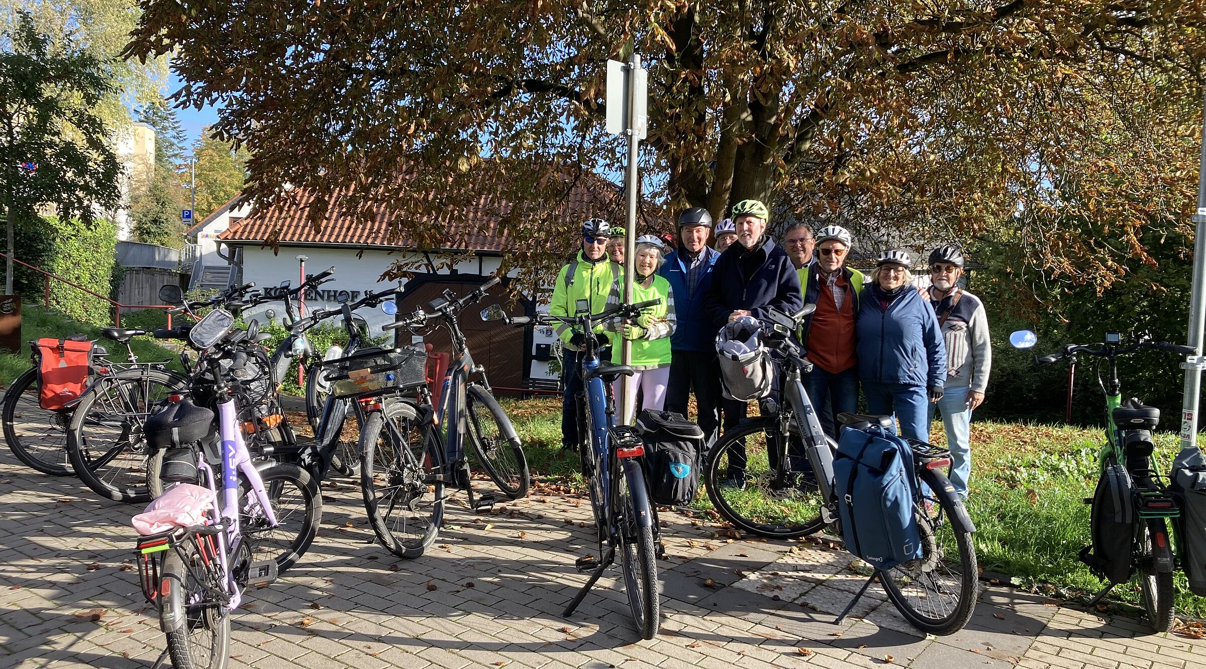 Das Bild zeigt die 12 Teilnehmer*innen der Tour mit ihren Rädern vor dem Köllenhof