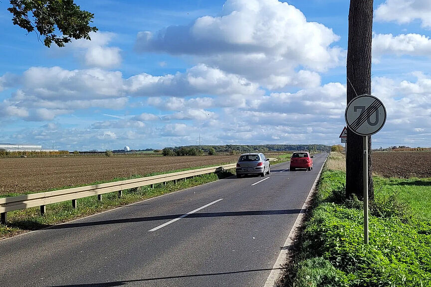Foto zum Bürgerantrag Tempo 70 Das Bild zeigt einen gefährlichen Überholvorgang auf einer Landstraße zwischen Adendorf und Arzdorf in Wachtberg, an der Straße das Verkehrsschild: Geschwindigkeitsbegrenzung aufgehoben, daneben das Schild: Gefahr vor Wildwechselm