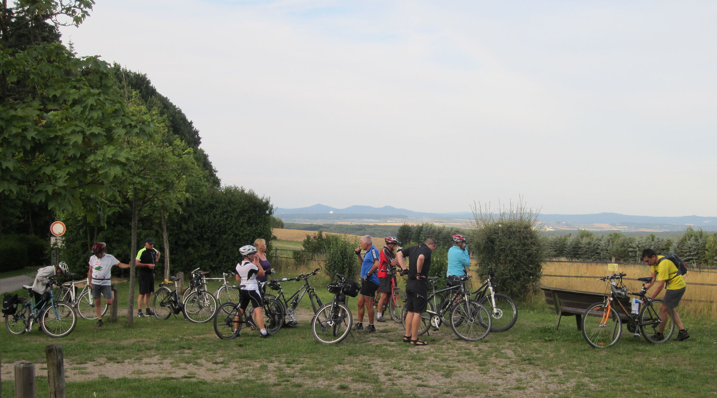 Das Bild zeigt eine Gruppe von Radlern, die Rast machen und dabei einen schönen Blick von Wachtberg auf das Siebengebirge auf der gegenüberliegenden Rheinseite haben.