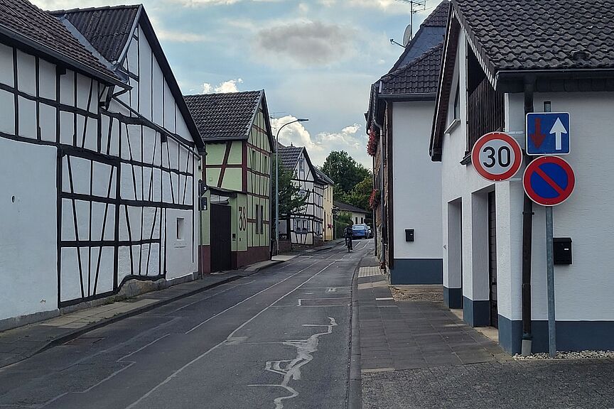 Tempo 30 Werthhoven Das Foto zeigt eine Engestelle an einer viel von Kindern genutzten Straße in Werthhoven mit einem Tempo 30 Schild