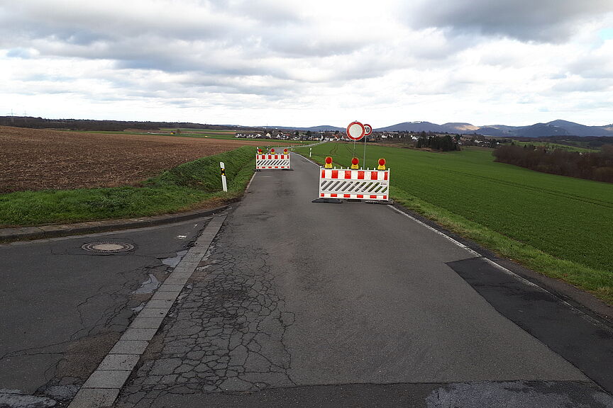 Sperrung Berkumer Weg Das Bild zeigt die Sperrung des Berkumer Weges mit Sperrgittern. Das Verkehrsschild Durchfahrt verboten muss korrigiert werden, da Fuss- und Radverkehr frei sind.