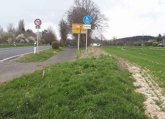 Das Bild zeigt den Blick entlang der Landstraße Richtung Berkum, unterhalb der Verkehrsschilder endet der Radweg