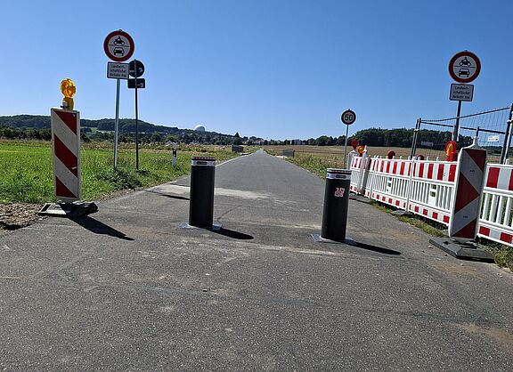 Das Bild zeigt die mit zwei versenkbaren Pollern abgespertte Fahrradstraße Berkumer Weg in Wachtberg