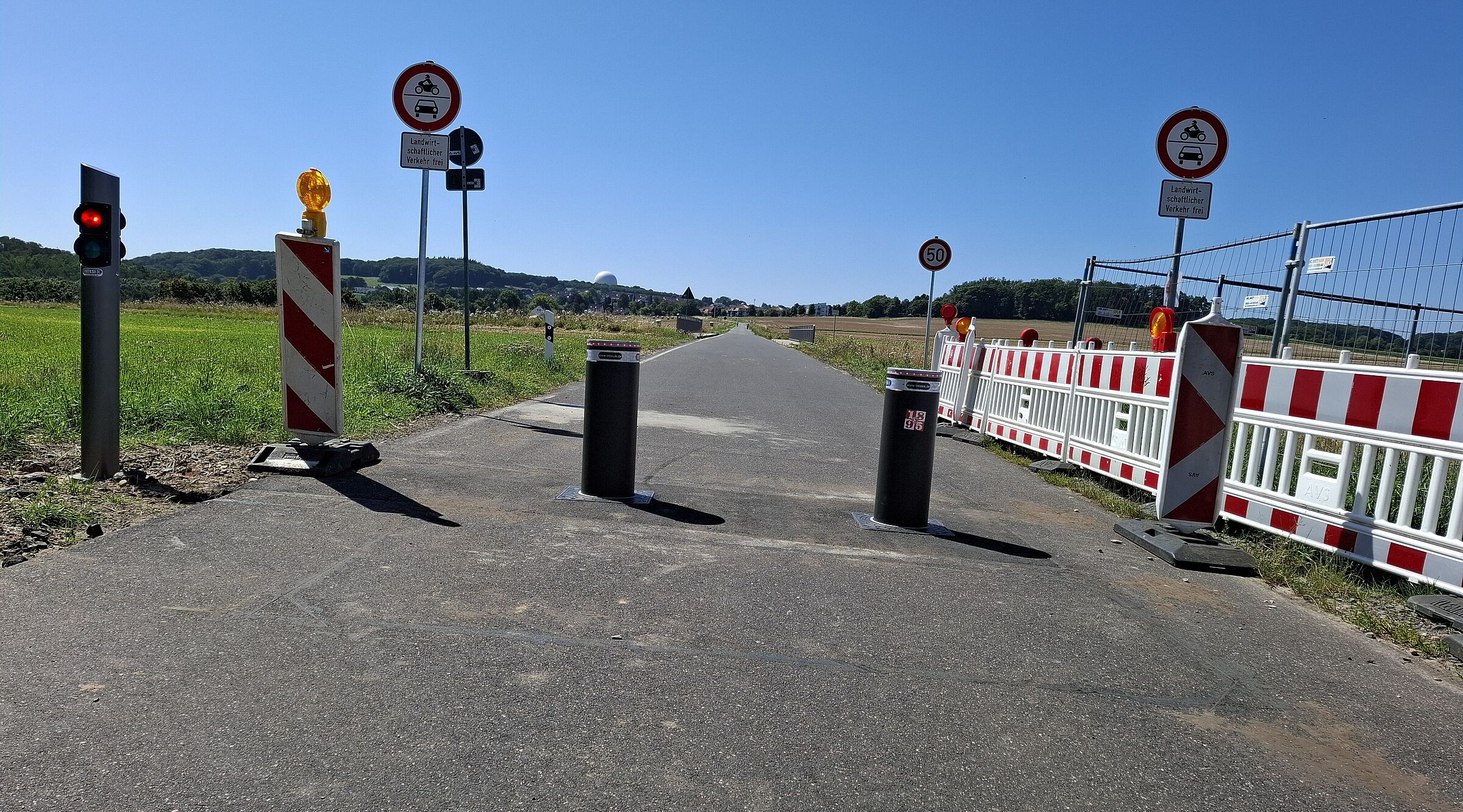 Das Bild zeigt die mit zwei versenkbaren Pollern abgespertte Fahrradstraße Berkumer Weg in Wachtberg