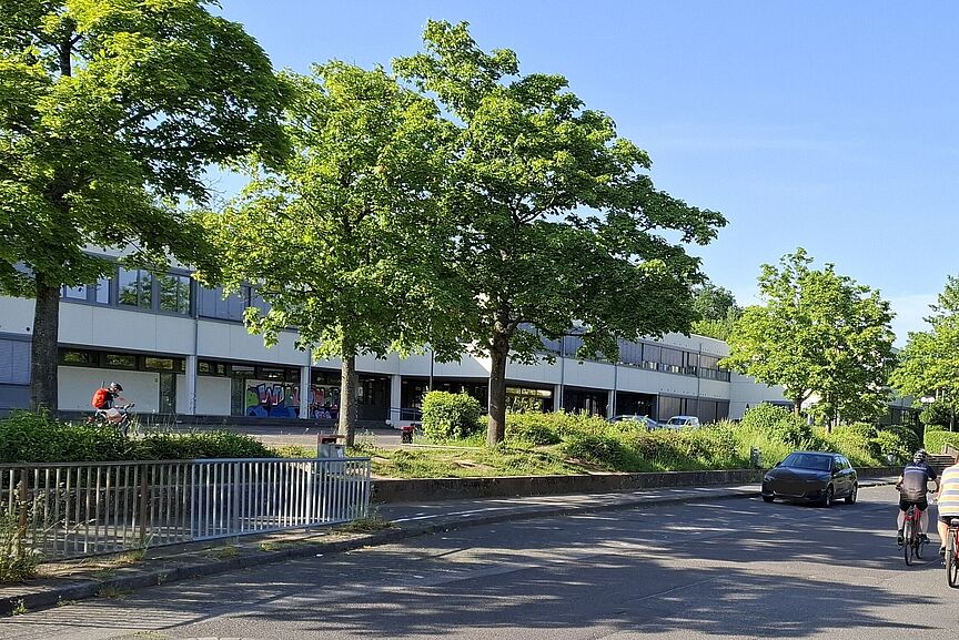 Fahrradstraße Stumpebergweg? Das Bild zeigt die Straße vor der Schule in Berkum, mit einigen Radfahrern im Vordergrund und dem Schulgebäude im Hintergrund