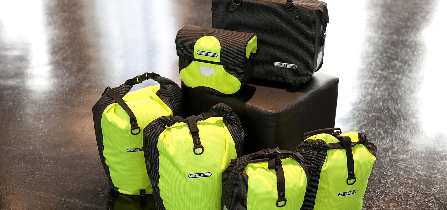 Komplett reflektierende Taschenset mit Back- und Frontrollern und Lenkertasche in gelb, Fahrradaktentasche in schwarz.